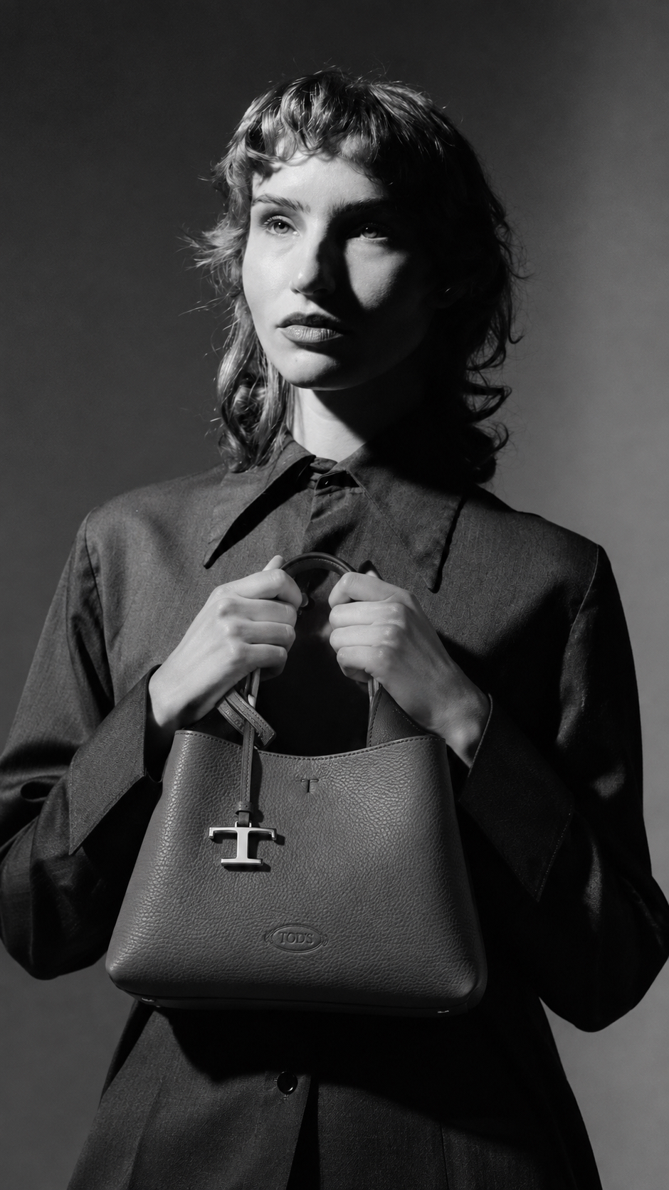 Black and white portrait of a woman with a designer handbag